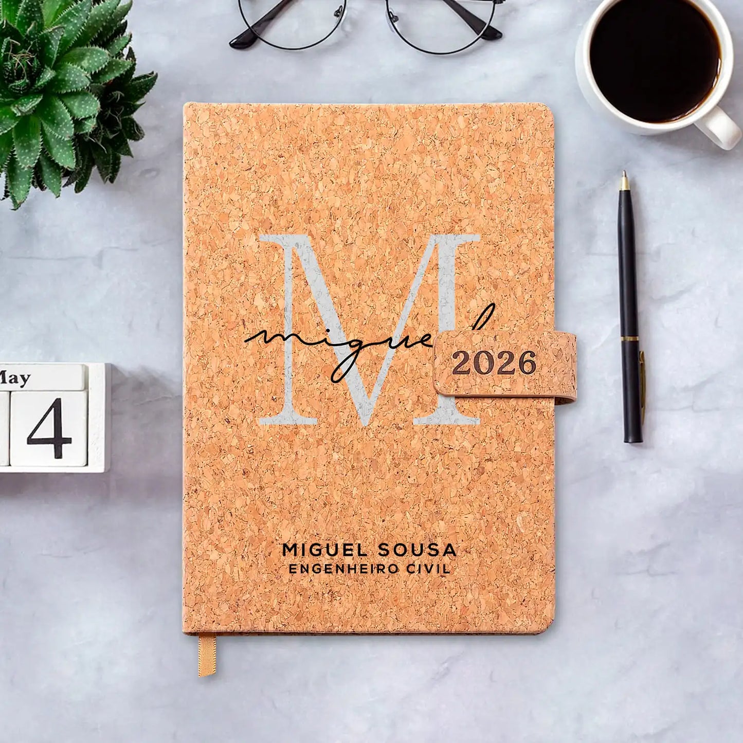 Agenda diária 2026 personalizada com nome e profissão. Capa em cortiça com fecho magnético, formato A5.