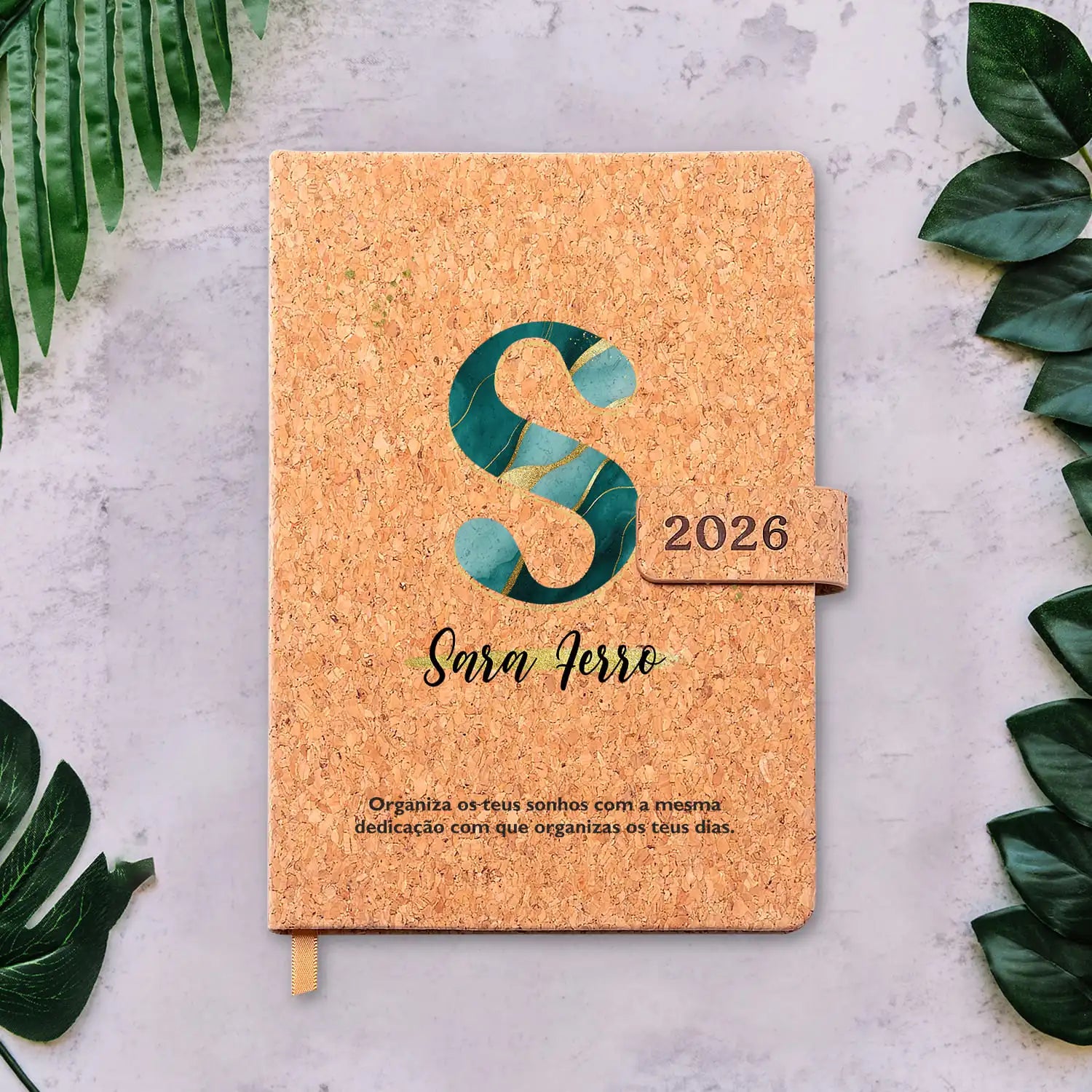 Agenda diária 2026 personalizada com nome e frase. Capa em cortiça com fecho magnético, formato A5.
