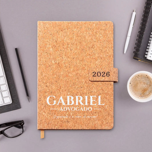 Agenda diária 2026 personalizada com nome, profissão e frase. Capa em cortiça com fecho magnético, formato A5.