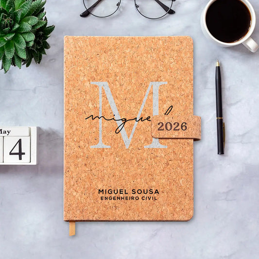Agenda diária 2026 personalizada com nome e profissão. Capa em cortiça com fecho magnético, formato A5.