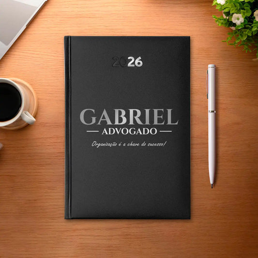 Agenda diária 2026 personalizada com nome, profissão e frase. Capa rígida PU, formato A5.