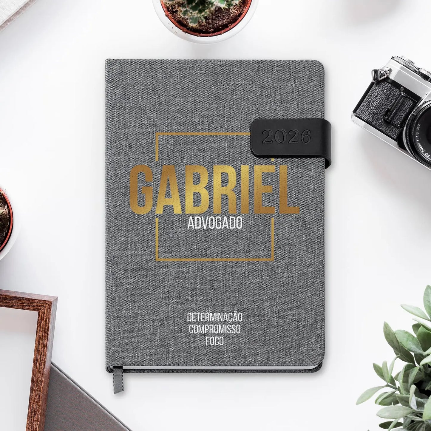 Agenda diária 2026 personalizada com nome e profissão. Capa em tecido com fecho magnético, formato A5.