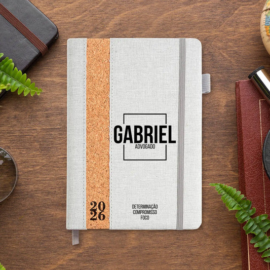 Agenda diária 2026 personalizada com nome e profissão. Capa em linho e cortiça, formato A5.