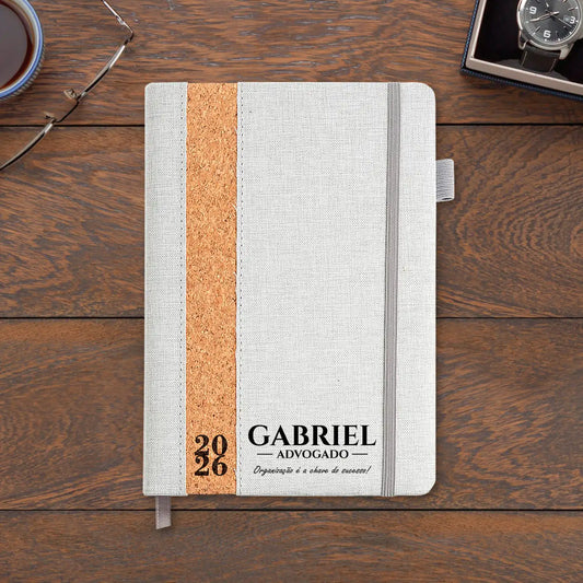 Agenda diária 2026 personalizada com nome, profissão e frase. Capa em linho e cortiça, formato A5.