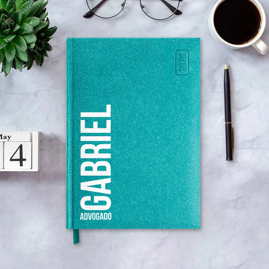Agenda diária 2026 personalizada com nome e profissão. Capa rígida em papel craft, formato A5.