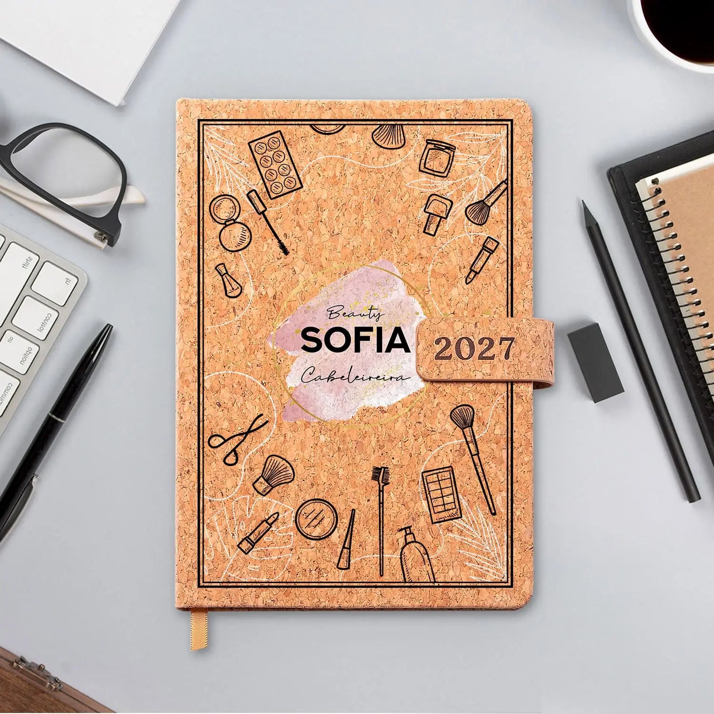 Agenda diária 2027 personalizada com nome e profissão. Capa em cortiça com fecho magnético, formato A5.