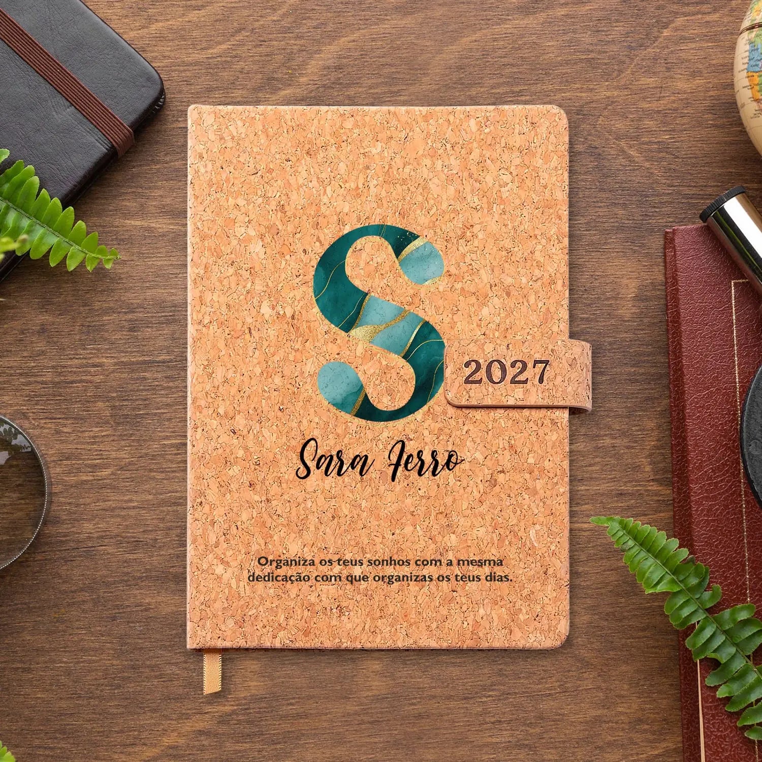 Agenda diária 2027 personalizada com nome e frase. Capa em cortiça com fecho magnético, formato A5.