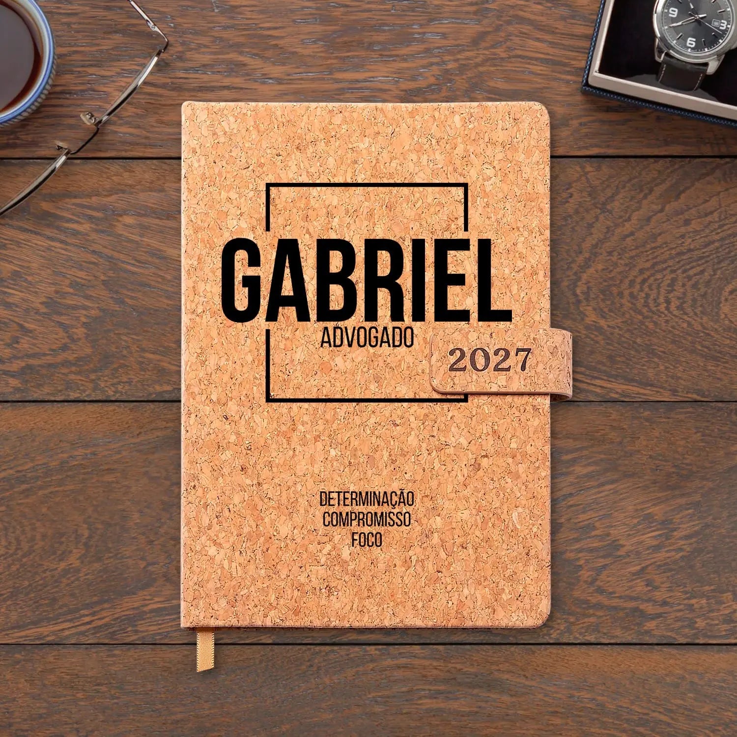 Agenda diária 2027 personalizada com nome e profissão. Capa em cortiça com fecho magnético, formato A5.