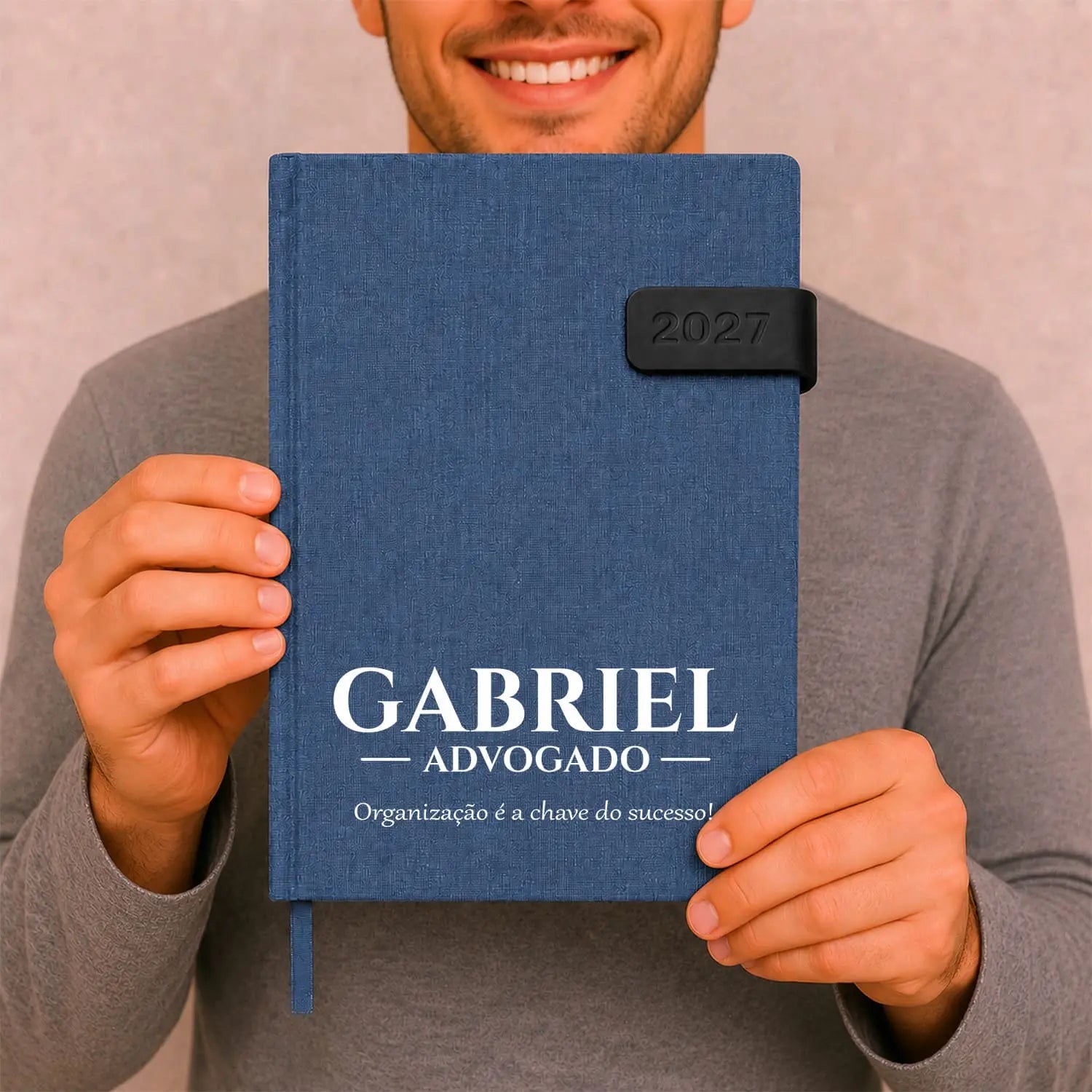 Agenda diária 2027 personalizada com nome, profissão e frase. Capa em tecido com fecho magnético, formato A5.