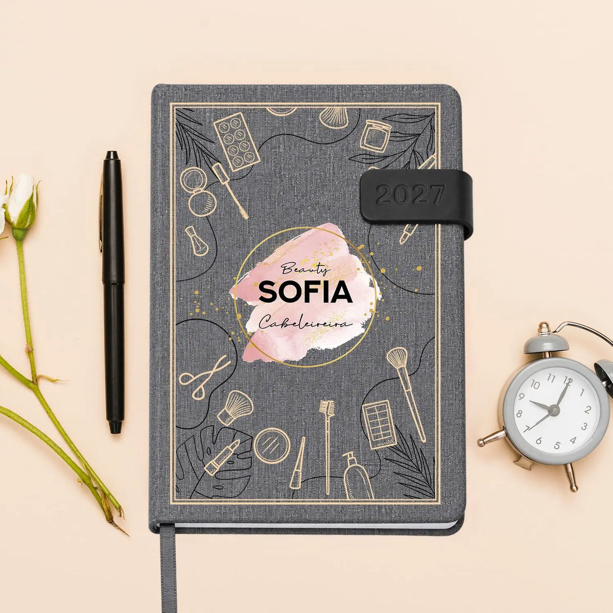 Agenda diária 2027 personalizada com nome e profissão. Capa em tecido com fecho magnético, formato A5.