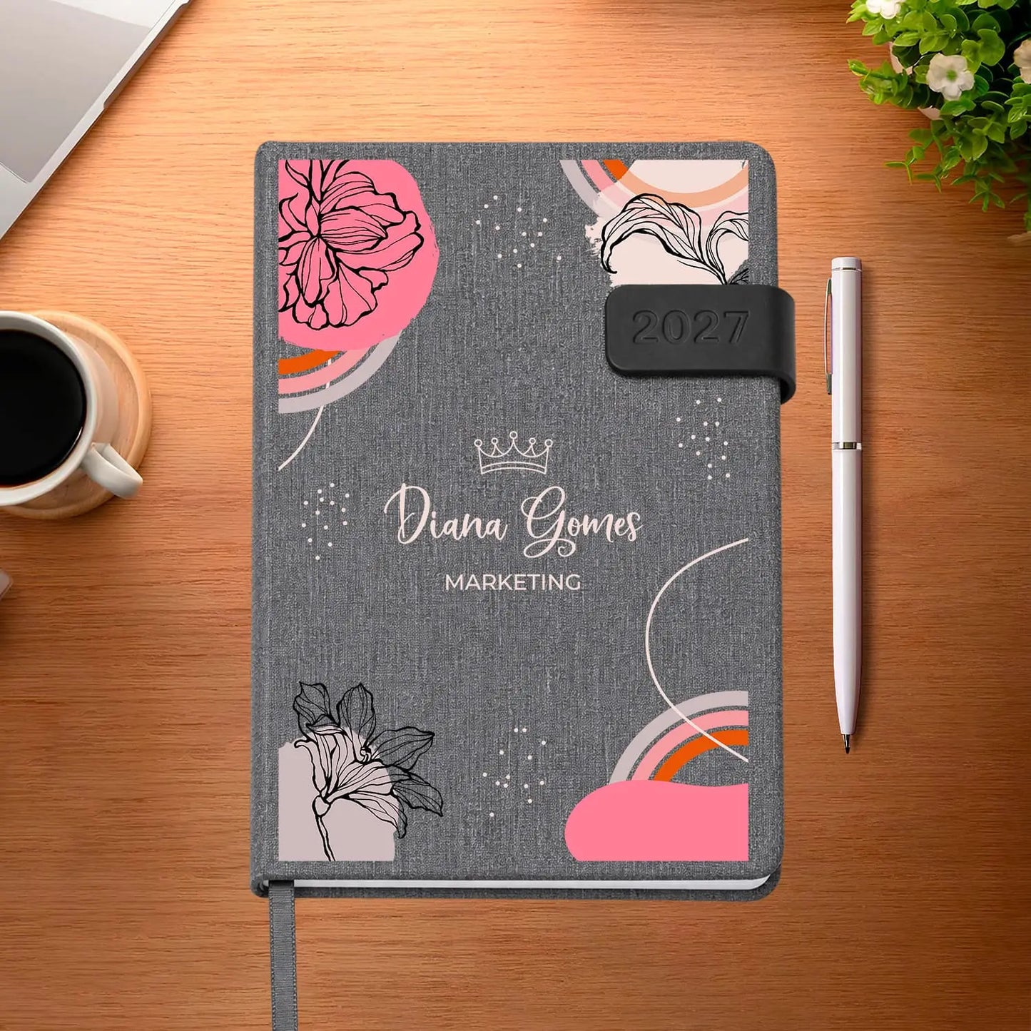 Agenda diária 2027 personalizada com nome e profissão. Capa em tecido com fecho magnético, formato A5.