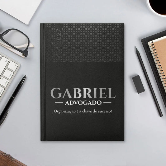 Agenda semanal 2027 personalizada com nome, profissão e frase. Capa em PU, formato A5+.
