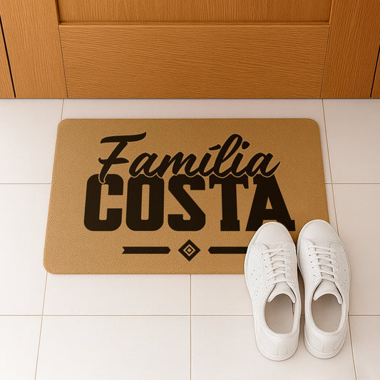 Tapete de entrada personalizado com apelido(s) da família. Superfície de fibra sintética. Base de borracha preta antiderrapante. 40x60 cm.